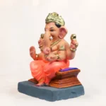 Side profile view of 12 inch Chaurang Orange KP eco-friendly clay Ganesh idol seated on throne