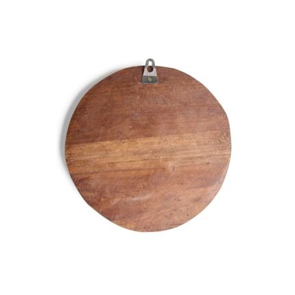 Side-angle view of round wooden elephant wall hanging showing grain texture and depth