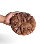 Another angle view of round wooden elephant wall hanging showing carved details and natural wood texture